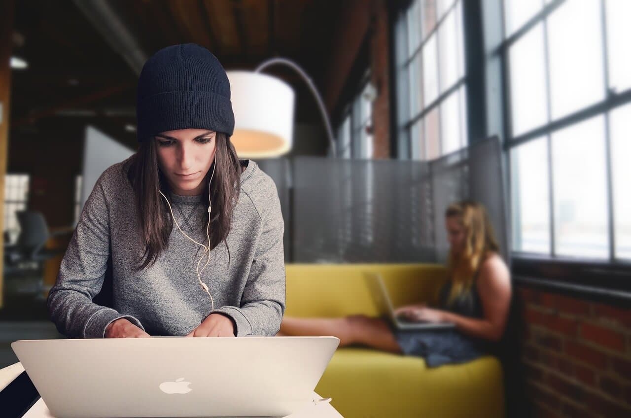 A coworking space with a woman working on a laptop in a vibrant, modern setting.