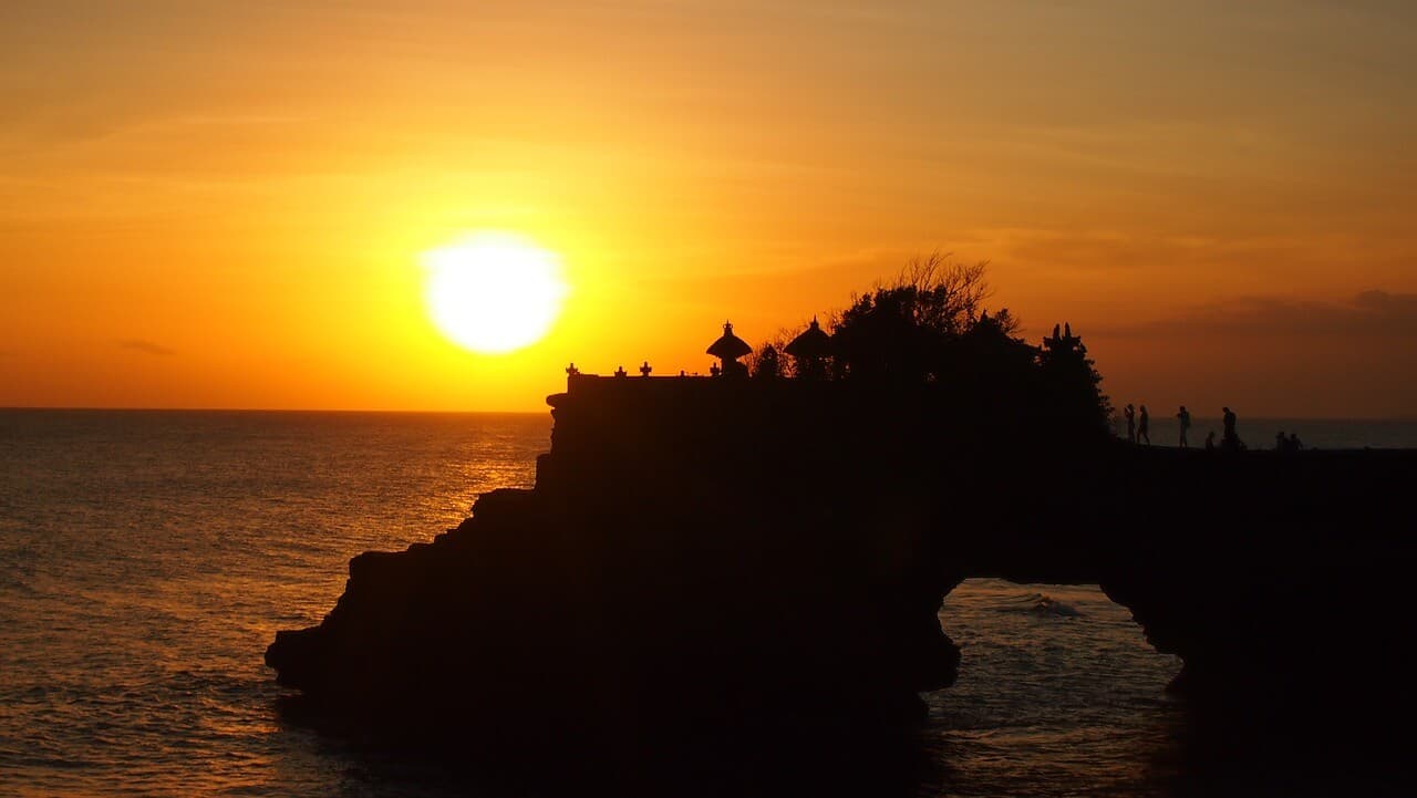 Beautiful Balinese temple silhouetted against a vibrant sunset sky
