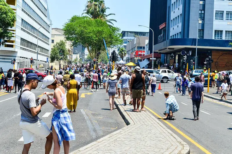 Bree Street in Cape Town, showcasing a lively atmosphere with people walking, shops, cafes, and vibrant street life, reflecting the city's culinary