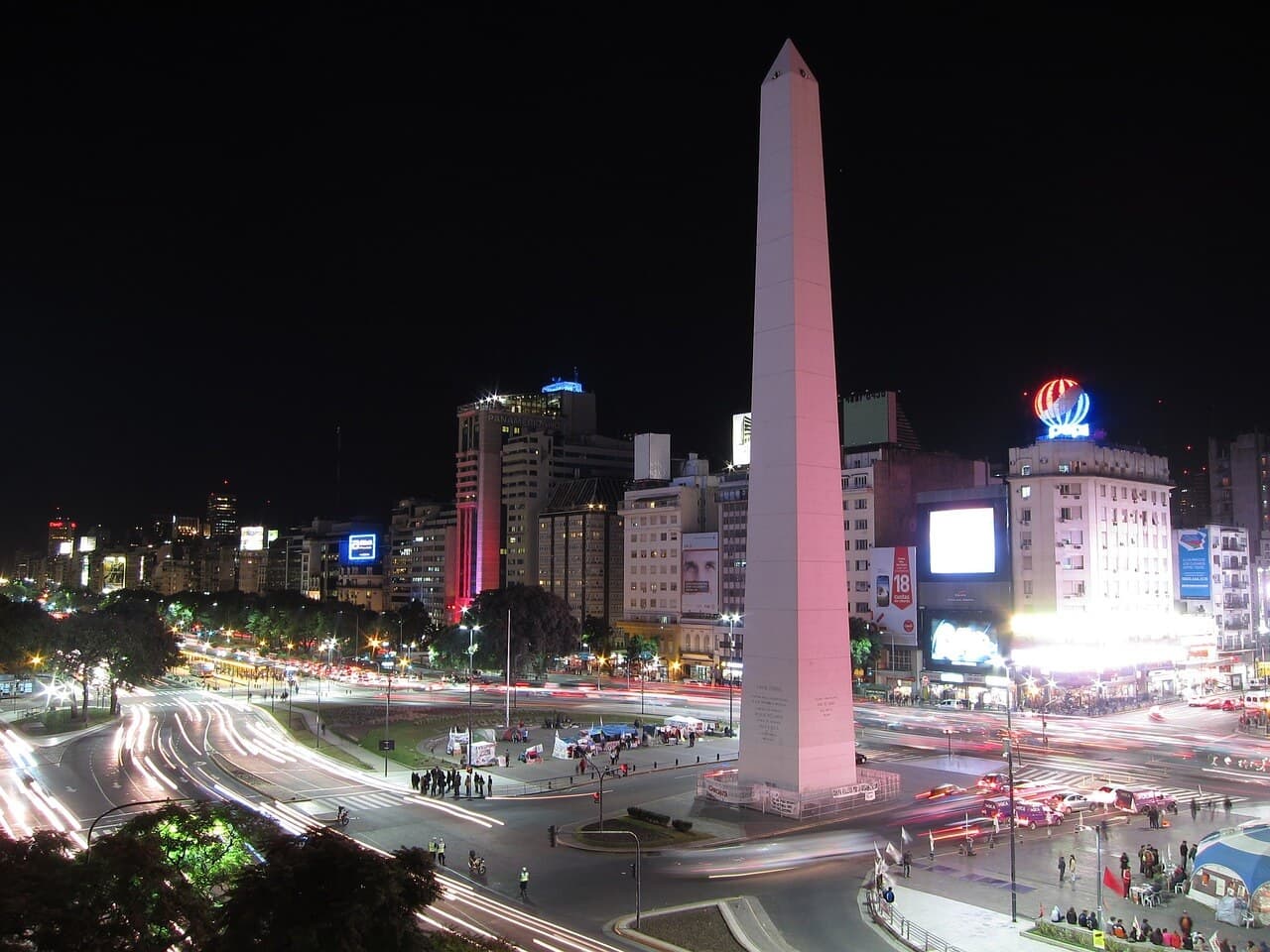 A night view of the Obelisk in Buenos Aires, Argentina, surrounded by city lights and bustling streets