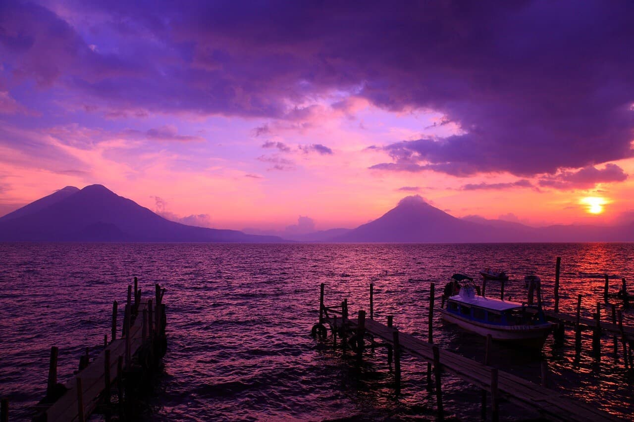 A stunning purple-hued view of Lake Atitlán, Guatemala, surrounded by mountains and serene natural beauty