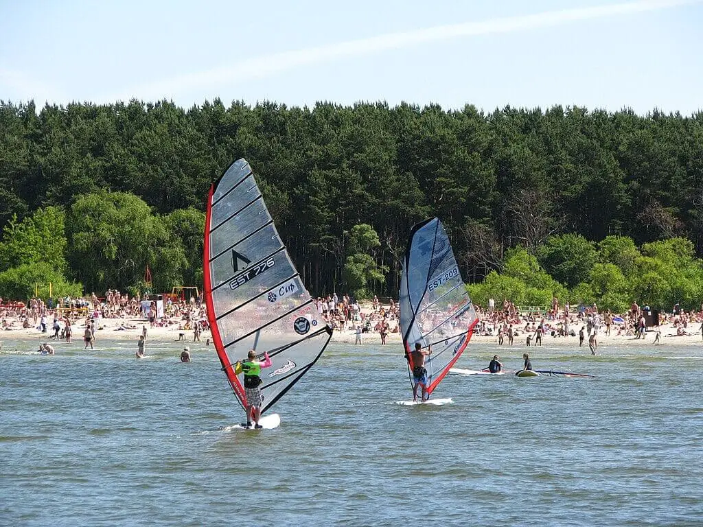 Sunny summer day at Pirita Beach in Tallinn, Estonia, with people enjoying the sandy shore and the calm sea